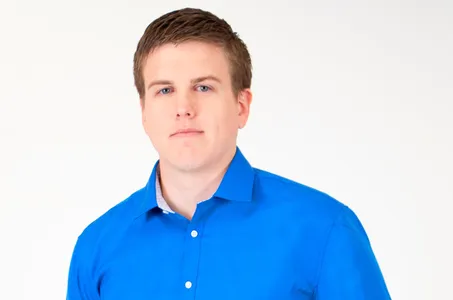 Dr. Tate Burleson professional headshot in blue shirt – Burleson Chiropractic Portrait of Dr. Tate Burleson from Creekside Chiropractic, wearing a blue shirt and posing against a white background – Burleson Chiropractic